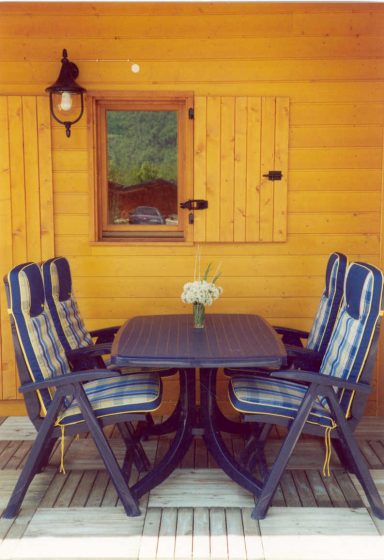 Veranda met tuinmeubilair Buitenmeubilair met vier stoelen en een tafel, voor het chalet