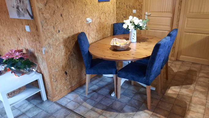 Eethoek in woonkeuken Een houten tafel met blauwe stoelen en bloemenvaas in een gezellige woonkeuken