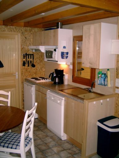 Complete keuken Moderne keuken met houten kasten, een wasbak, en apparaten zoals een vaatwasser en koffiezetter.