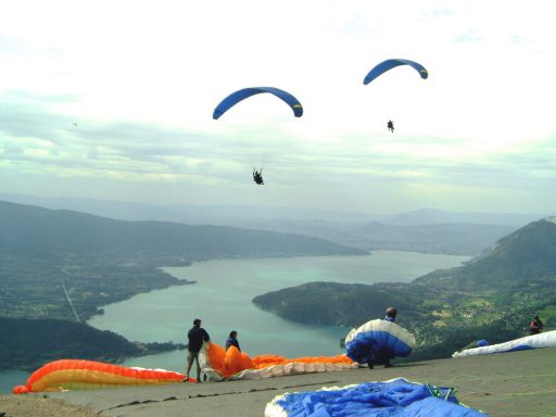 Parapenters Paragliders boven een meer, met bergen op de achtergrond gezien vanaf Col de la Forglaz